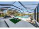 A screened pool and patio feature a dining area, lounge chairs, and a tranquil lake view at 3615 Pennyroyal Rd, Port Charlotte, FL 33953