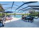 A screened pool and patio feature a dining area, lounge chairs, and a tranquil lake view at 3615 Pennyroyal Rd, Port Charlotte, FL 33953