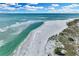 Breathtaking aerial view of a pristine beach with crystal-clear turquoise water on a sunny day at 38 Seawatch Lake Dr, Boca Grande, FL 33921