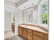 Bright bathroom features a vanity with double sinks, tiled backsplash, and a large mirror at 38 Seawatch Lake Dr, Boca Grande, FL 33921