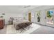 Bright bedroom featuring a large bed, soft rug, and a door to a small balcony at 38 Seawatch Lake Dr, Boca Grande, FL 33921
