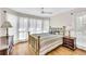 Comfortable bedroom featuring a brass bed frame, wood floors, and lots of natural light at 38 Seawatch Lake Dr, Boca Grande, FL 33921