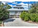 Inviting coastal home with a metal roof, charming windows, and meticulous landscaping at 38 Seawatch Lake Dr, Boca Grande, FL 33921