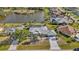 Expansive aerial view of a home near a lake, showcasing the pool and surrounding lush landscaping at 4 Sportsman Ln, Rotonda West, FL 33947