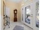 Inviting foyer with marble flooring, a decorative table, a grandfather clock, and a beautifully designed glass front door at 4 Sportsman Ln, Rotonda West, FL 33947