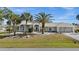 Elegant single-story home featuring a three-car garage and meticulously landscaped front yard with mature palm trees at 4 Sportsman Ln, Rotonda West, FL 33947