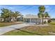 Charming home featuring a three-car garage, and a beautifully landscaped front yard with mature palm trees at 4 Sportsman Ln, Rotonda West, FL 33947