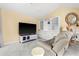 Living room with white tile floors, a large TV, and a built-in display cabinet at 4 Sportsman Ln, Rotonda West, FL 33947