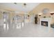 Spacious living room featuring white tile floors, fireplace, and arched doorway leading to the dining area at 4 Sportsman Ln, Rotonda West, FL 33947