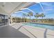 Enclosed pool area featuring a pristine pool with a view of the lake and tropical landscaping at 4 Sportsman Ln, Rotonda West, FL 33947