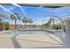 Relaxing screened-in pool with serene lake views and picturesque palm tree landscaping at 4 Sportsman Ln, Rotonda West, FL 33947