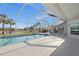 Inviting screened pool with lake views surrounded by lush tropical landscaping and blue skies at 4 Sportsman Ln, Rotonda West, FL 33947