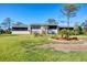 Rear exterior view of the home with a sprawling lawn and meticulously landscaped garden at 4260 Placida Rd # 8D, Englewood, FL 34224