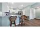 Bright kitchen features wood floors, breakfast bar with seating, stainless fridge, and white cabinets at 4260 Placida Rd # 8D, Englewood, FL 34224