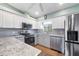Stainless steel appliances and stone countertops highlight this kitchen with wood floors and white cabinets at 4260 Placida Rd # 8D, Englewood, FL 34224