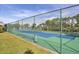 Exterior tennis court with blue and green surface surrounded by a tall green chain-link fence at 4260 Placida Rd # 8D, Englewood, FL 34224