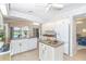 Well-lit kitchen with white cabinets, center island, granite countertops, and open layout to living area at 6 Windward Ct, Placida, FL 33946