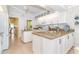 Spacious kitchen featuring white cabinets, granite countertops, center island, and open layout to dining area at 6 Windward Ct, Placida, FL 33946