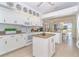 Bright kitchen with white cabinetry, granite countertops, center island, and breakfast nook overlooking the pool at 6 Windward Ct, Placida, FL 33946
