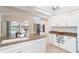 Bright kitchen with white cabinetry, granite countertops, center island, and view of screened-in lanai at 6 Windward Ct, Placida, FL 33946