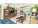 Spacious living room with vaulted ceiling, entertainment center, comfortable seating, and view of screened-in pool at 6 Windward Ct, Placida, FL 33946