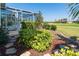 Professionally landscaped yard offers a beautiful view of the screened in lanai and green golf course at 6 Windward Ct, Placida, FL 33946