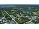 An aerial view of a charming home nestled in a quiet neighborhood near a lake surrounded by lush greenery at 6368 Pennell St, Englewood, FL 34224