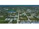 An aerial view of a charming home nestled in a quiet neighborhood near a lake and surrounded by lush greenery at 6368 Pennell St, Englewood, FL 34224
