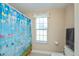 Bright bathroom featuring a butterfly shower curtain and a window view at 6368 Pennell St, Englewood, FL 34224