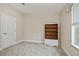 Clean bedroom with gray carpet, featuring a bookshelf and a window at 6368 Pennell St, Englewood, FL 34224