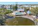 Aerial view of the community pool next to the pond and manicured grounds at 6610 Gasparilla Pines Blvd # 113, Englewood, FL 34224