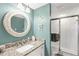 Cozy bathroom with vanity, decorative mirror, granite countertop, and glass enclosed shower at 6610 Gasparilla Pines Blvd # 113, Englewood, FL 34224