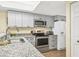 This kitchen features stainless steel appliances, granite countertops, and sleek gray cabinetry at 6610 Gasparilla Pines Blvd # 113, Englewood, FL 34224