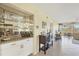 Living space with a mirrored bar area, neutral decor, and a view of the screened-in porch at 6610 Gasparilla Pines Blvd # 113, Englewood, FL 34224