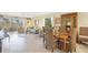 Open-concept living area with tile floors, wicker seating, and a picturesque outdoor view at 6610 Gasparilla Pines Blvd # 113, Englewood, FL 34224