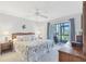 Serene main bedroom with a king bed, ceiling fan, and access to a private screened porch at 6610 Gasparilla Pines Blvd # 113, Englewood, FL 34224
