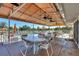 Covered outdoor seating area with multiple tables and chairs, overlooking the community pool and lounging area at 6610 Gasparilla Pines Blvd # 113, Englewood, FL 34224