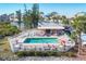 Overhead view of the community pool, surrounded by condos and well-manicured lawns at 6610 Gasparilla Pines Blvd # 113, Englewood, FL 34224