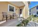 Cozy porch with seating and front door to a yellow home at 6610 Gasparilla Pines Blvd # 113, Englewood, FL 34224