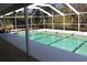Backyard pool enclosed with screens and view of tropical foliage at 6980 Tuxedo St, Englewood, FL 34224