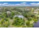 Aerial view of a home nestled within lush greenery with scenic views of the lake and surrounding landscape at 730 Buckskin Ct, Englewood, FL 34223