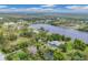 Picturesque aerial view of a lakefront property, showcasing a house, lush greenery, and a serene water setting at 730 Buckskin Ct, Englewood, FL 34223