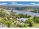 Breathtaking aerial shot capturing a home nestled by a tranquil lake, lush trees, and serene surroundings at 730 Buckskin Ct, Englewood, FL 34223
