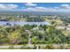 Sprawling aerial view of a property featuring a large lake, multiple buildings, and lush, green surroundings at 730 Buckskin Ct, Englewood, FL 34223