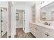Bathroom with modern vanity, white cabinets, and decorative mirror at 730 Buckskin Ct, Englewood, FL 34223