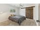 Bedroom featuring carpet, a ceiling fan, and a sliding barn door, all illuminated by natural light at 730 Buckskin Ct, Englewood, FL 34223