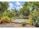 Wooden dock on a tranquil pond surrounded by lush greenery, providing a serene waterfront setting at 730 Buckskin Ct, Englewood, FL 34223