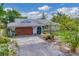Charming home with a quaint front exterior, featuring mature landscaping and a private driveway at 730 Buckskin Ct, Englewood, FL 34223