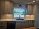 Modern kitchen with gray cabinets, white backsplash, and sink with a view of a lake at 730 Buckskin Ct, Englewood, FL 34223