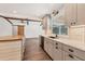 Well-lit kitchen boasts a butcher block island, stone backsplash, stainless appliances, and wood-look tile floor at 730 Buckskin Ct, Englewood, FL 34223